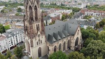 Drone panning out to reveal the surrounding area around the Great Saint Martin Church in Cologne, Germany.