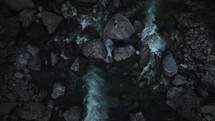 Top down aerial view of a scenic mountain river flowing through huge rocks at night