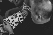 a grandfather holding his newborn grandchild 