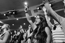 teens with raised hands at a rally 