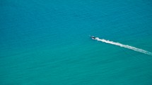 Small boat drives on crystal clear blue water to exotic island. Boat trip. Long Tail Boat. 