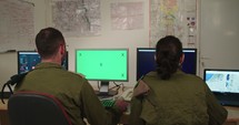 Israeli soldiers in a military command and control room looking at screens