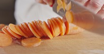 Slow motion close up of a chef knife slicing a carrot