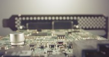 Extreme macro dolly shot of a PCB computer board with capacitors and transistors