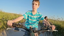 POV of a young boy enjoying riding his bicycle on the rural countryside.