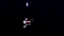 Different pills falling on black background. Drugs, pills, antibiotics, vitamins, healthcare, pharmaceutical industry, drug use, medicine concept. Slow motion