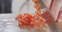 Extreme macro of a chef knife slicing a red bell pepper