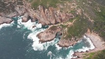 Aerial view of waves crashing against a granite rock shore on Tung Lung Island in Hong Kong.
