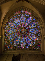 stained glass circular window, decorated with intricate designs resembling the petal arrangement of a rose. characteristic feature of Gothic architecture churches