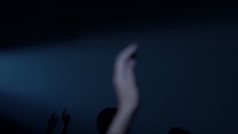 silhouettes of raised hands at a contemporary worship service 