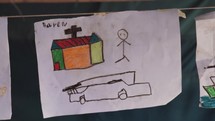 Christian Kid Drawing Church with Cross on The Roof on a Paper with Crayons