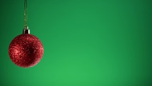 Red Christmas ball with green Background 