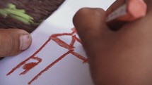 Christian Kid Drawing Church with Cross on The Roof on a Paper with Crayons
