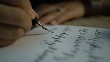 a woman writing in calligraphy 