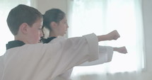 Slow motion footage of young kids practicing martial arts.