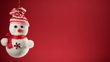 Tiny snowman decoration for Christmas with red background 
