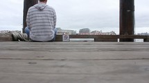 a man sitting alone on a dock 