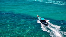 Small boat drives on crystal clear blue water to exotic island. Boat trip. Long Tail Boat. 