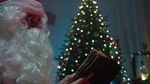Santa Claus reading under the Christmas tree 