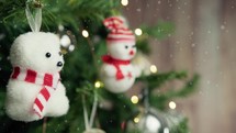 Small polar bear and snowman decorating a Christmas tree 
