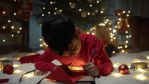Boy thinking about writing Christmas letter 