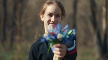 A young girl holding bouquet of spring flowers 