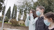 Coronavirus pandemic - kids walking outdoors with face masks to avoid contagion