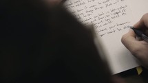 person writing notes in a journal 