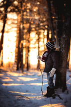 a boy standing in the woods in winter 