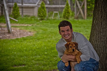 smiling man holding a puppy 