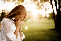 woman praying outdoors 