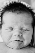 An infant with its eyes closed.