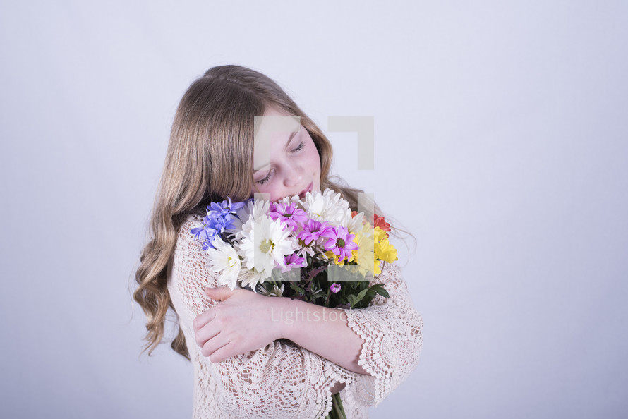 a little girl holding a bouquet of flowers 