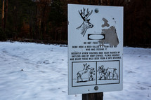 Do not feed the deer sign in the snow