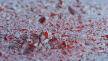 Crushed candy cane pieces falling in slow motion 