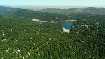 Aerial View Flying Backwards Over Lake Arrowhead and Surrounding Forest