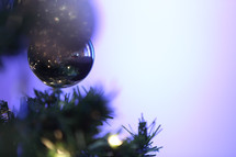 A Christmas ornament hanging on Christmas tree branches.