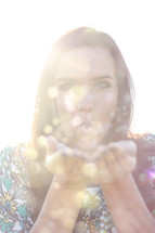 young woman blowing glitter 