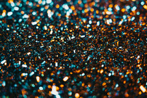 Festive golden dust, glitter background. Colorful blue and orange light. Copy space for art party project. Abstract sparkles shining, beautiful texture, bokeh. High quality photo