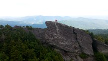 standing at the top of a mountain rock peak 