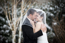 bride and groom kissing in the snow