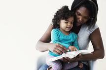 mother and daughter reading a Bible together 