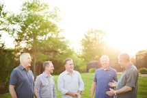 men standing in a backyard talking 