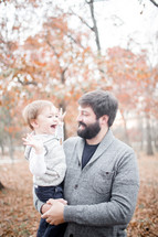 father holding his son outdoors in fall 