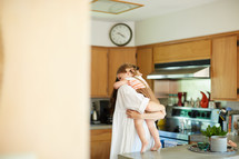 a mother hugging her daughter in a kitchen 