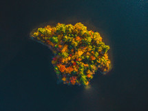 aerial view over lake and island in fall at sunset 