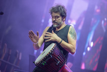 Man playing a drum at a concert 