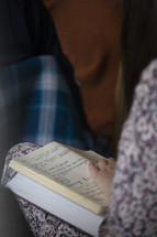 Woman seated in a row amongst others with notes and her Bible open