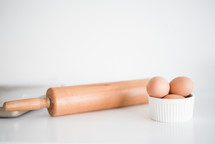 rolling pin and eggs in a bowl 