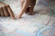 two people planning with fingers pointing to a map 
